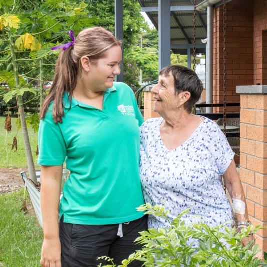 Trainee and resident arm in arm, smiling at each other