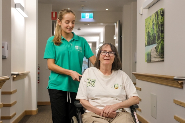 Student trainee smiling with client in a wheelchair
