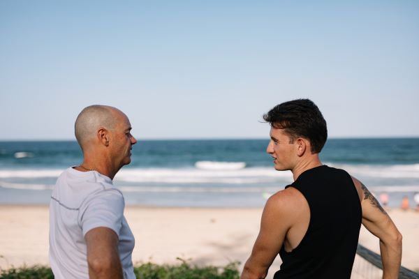 Two men talking at beach