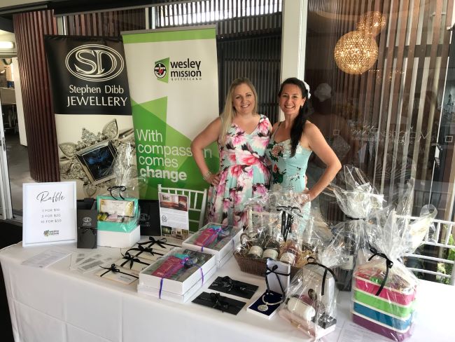 two-ladies-smiling-in-front-of-raffle-table