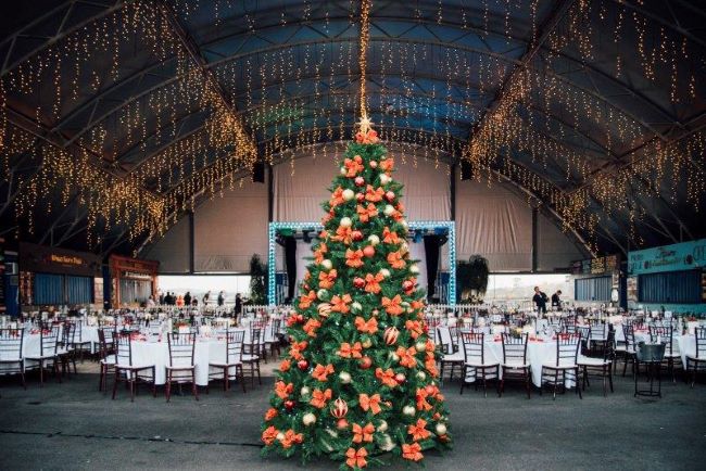 tables-dressed-for-elegant-function-with-christmas-tree-in-foreground