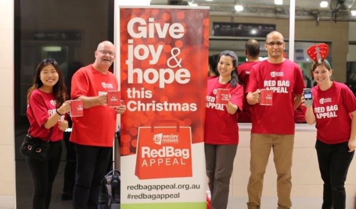 group-standing-in-front-of-red-bag-appeal-sign_updated