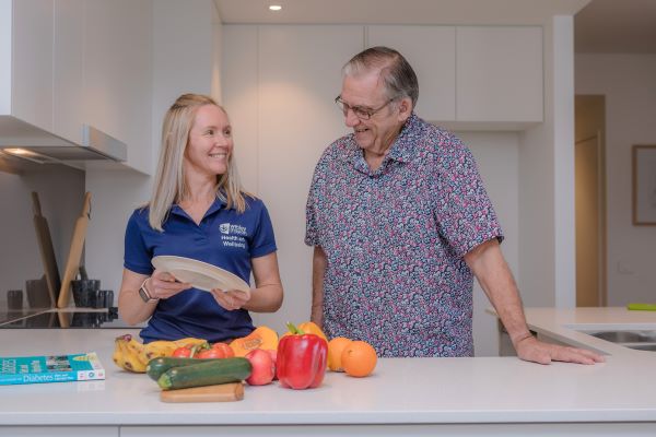 WMQ dietitian in the kitchen talking to a resident in one of our retirement communities in Brisbane