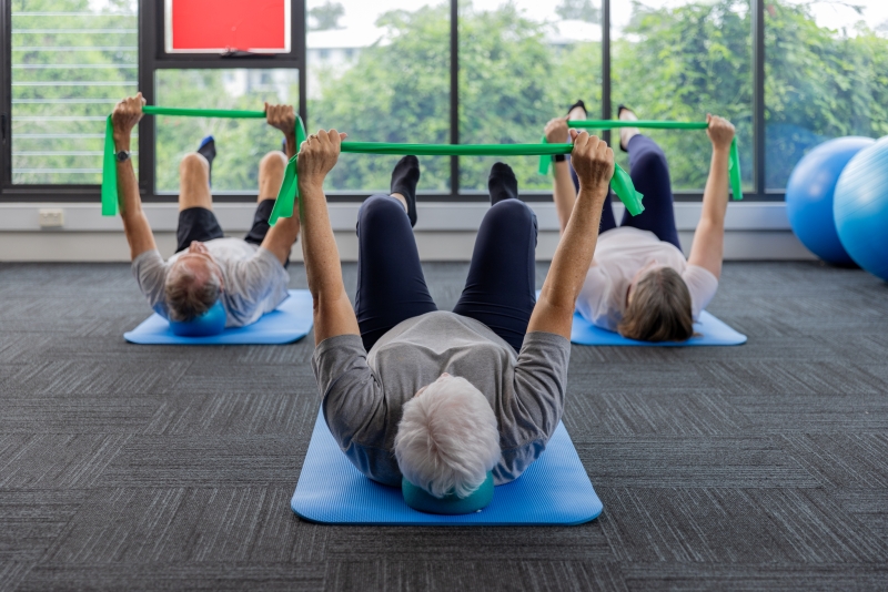 Three seniors taking a group pilates class