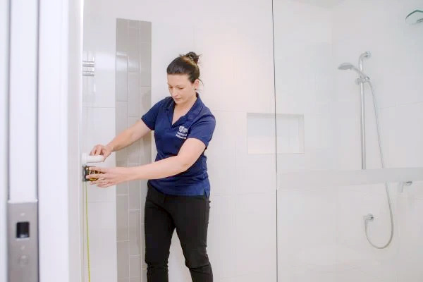 Occupational therapist measuring a bathroom wall