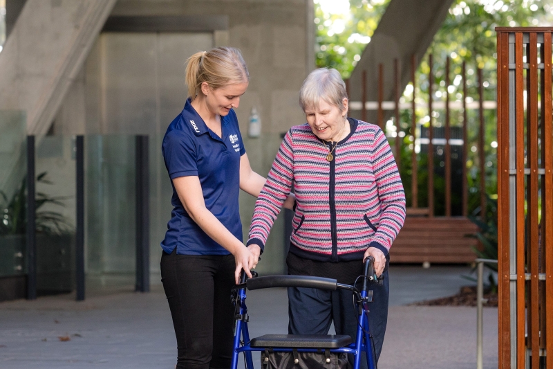 Occupational therapist working with a senior client using a walker