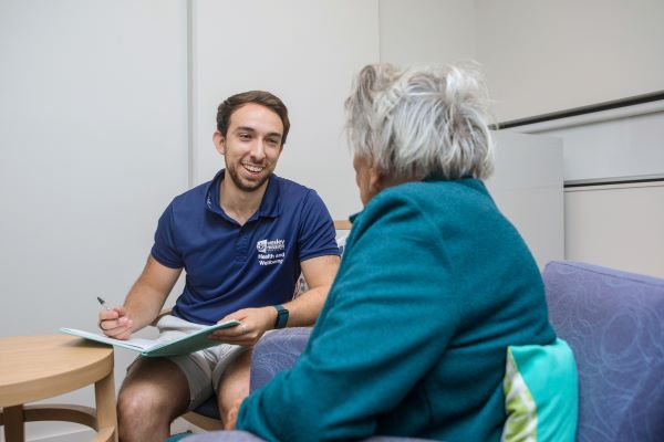 Therapist talking to client with pen and paper in hand