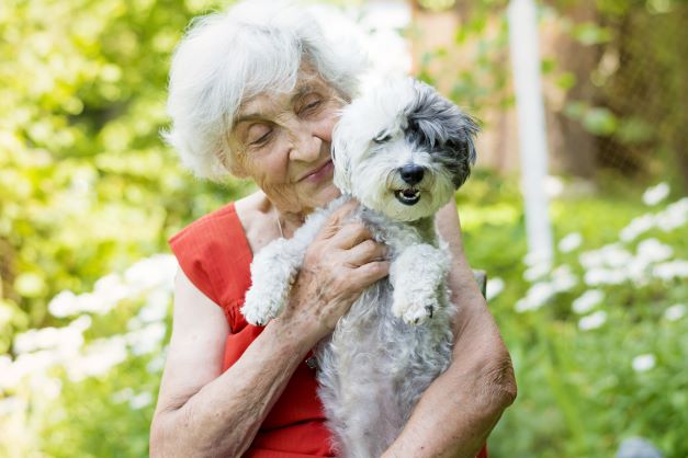 Retiree holding her dog in one of our pet friendly aged care communities.