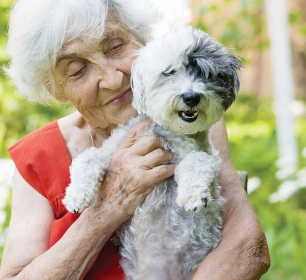 Retiree holding her pet dog in one of our aged care communities in Brisbane