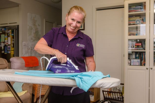 In home worker completing ironing duties