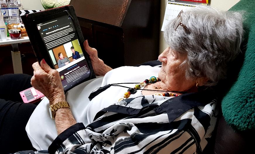 Old woman lying back with an ipad