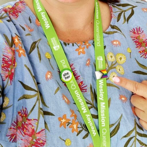 close up of someone pointing to their WMQ pronoun badge