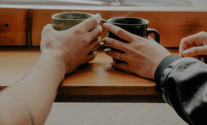 Peer led support at a Safe Space - Image shows two people holding hands