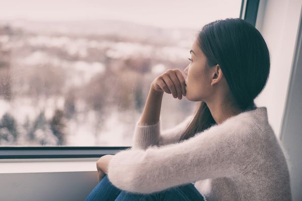 Woman looks out window