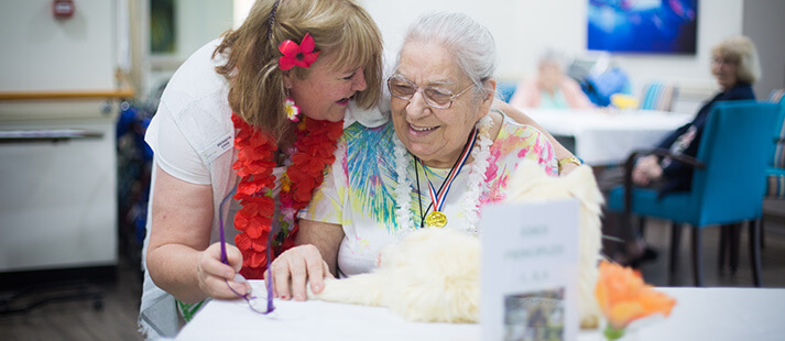 Aged care staff and resident celebrating