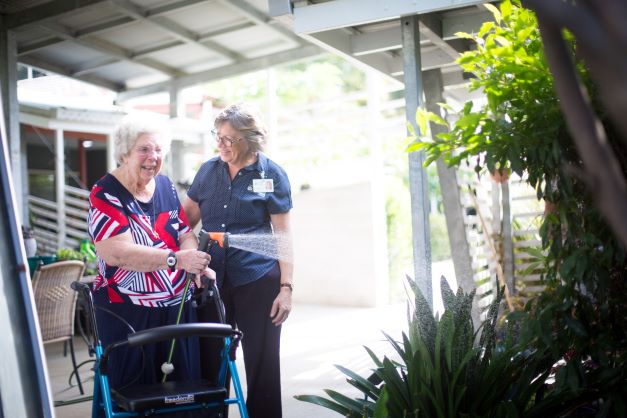 Resident watering the garden at Anam Cara