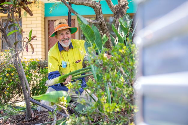 Coper House gardener smiling whilst attending to plants