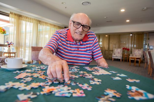 Cooper House resident finishing a jig saw puzzle