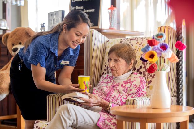 Staff member giving resident a cup of tea