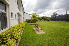 Exterior of building with grass, fence and seat