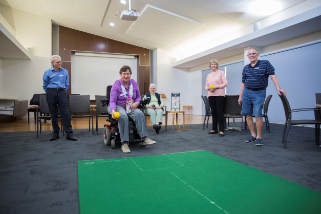 Retirees play indoor bowls in  our residential aged care community in Brisbane