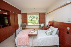 Bedroom with window, single bed, overbed table, built in storage and TV