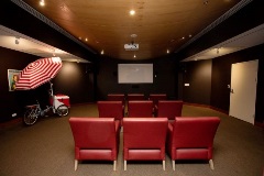 Cinema chairs facing screen with popcorn stand