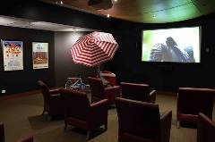 Cinema chairs facing screen with popcorn stand