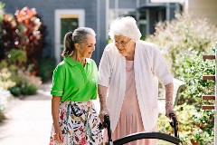 Staff and resident smiling in the green outdoors of our Parkview Residential Aged Care community, in Brisbane