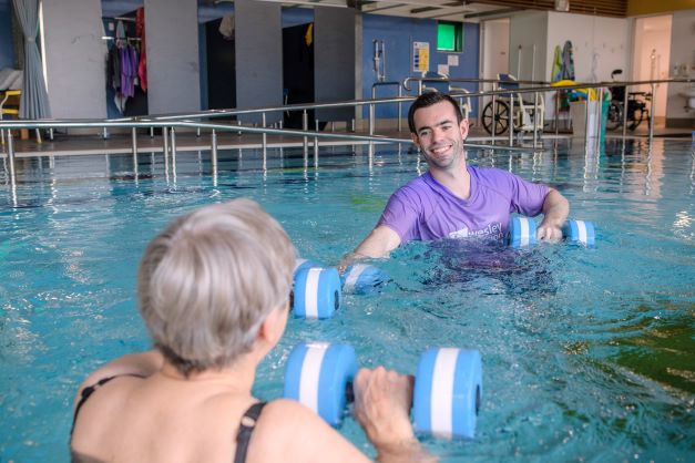 Client and staff member using light weights in hydrotherapy pool A resident working out in a hydrotherapy pool with staff member