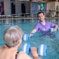 A resident working out in a hydrotherapy pool with staff member