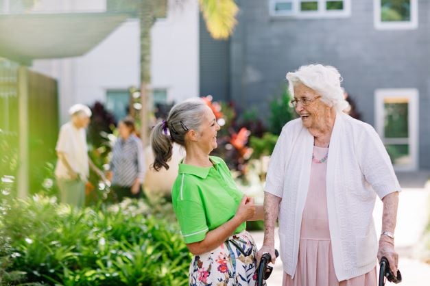 Residential aged care worker laughing together with a resident in one of our RAC communities