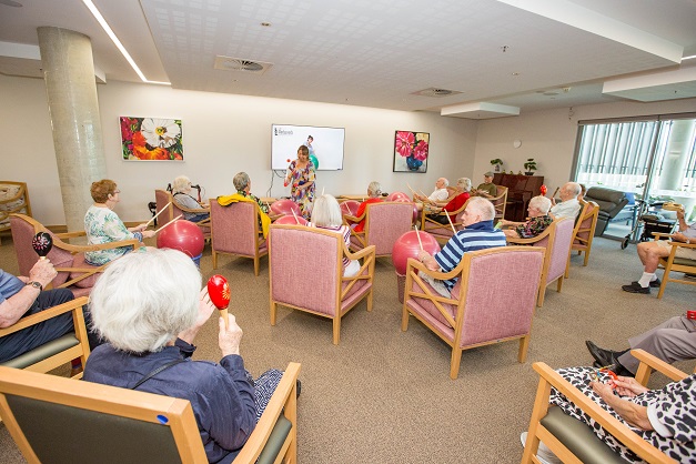 Hadden Place guests seated in the communal room taking part in gentle exercises