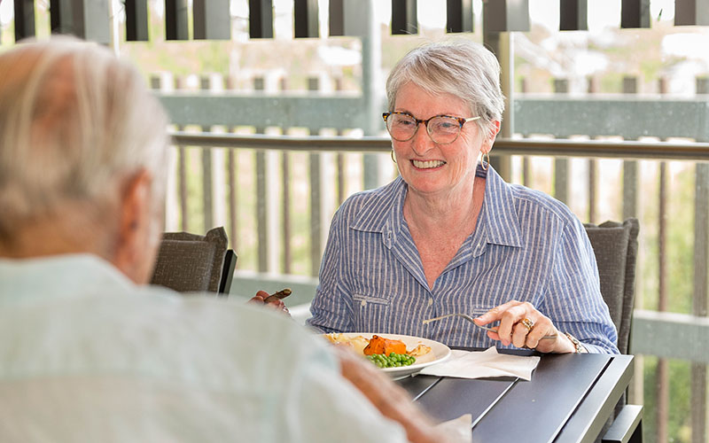 Lady eating a meal outdoors at Hadden Place respite centre