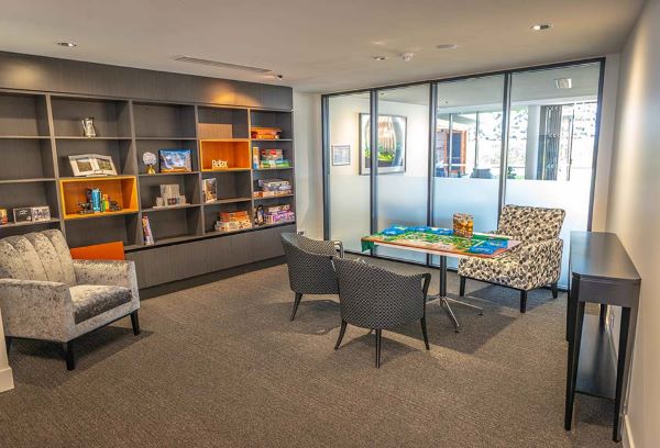 Rosemount library with shelves, armchairs and table with jigsaw puzzle