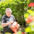 Retiree water the plants at Knowles Court residential aged care community, in Sinnamon Village precinct