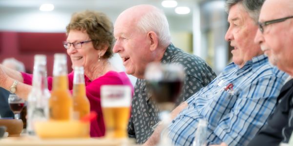 Residents laughing over drinks at Wheller on the Park