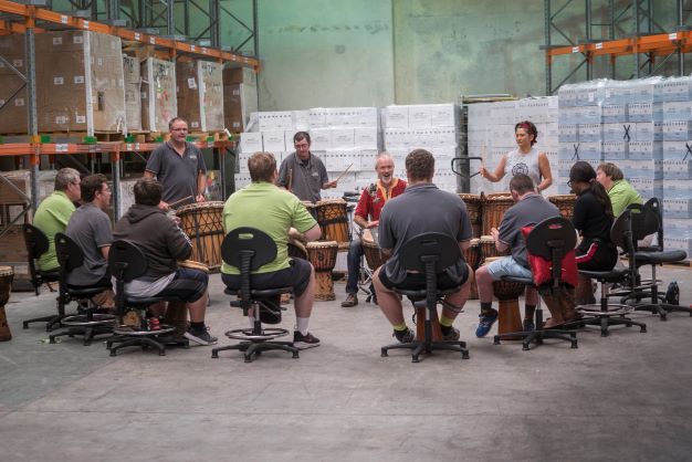 African drumming workshop with a group in a warehouse