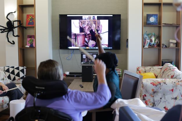 Residents enjoying an online drumming workshop