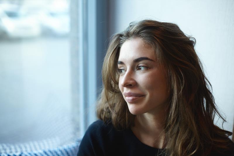 Young woman looking out window