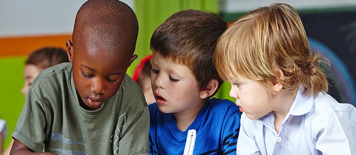 Three young children concentrating