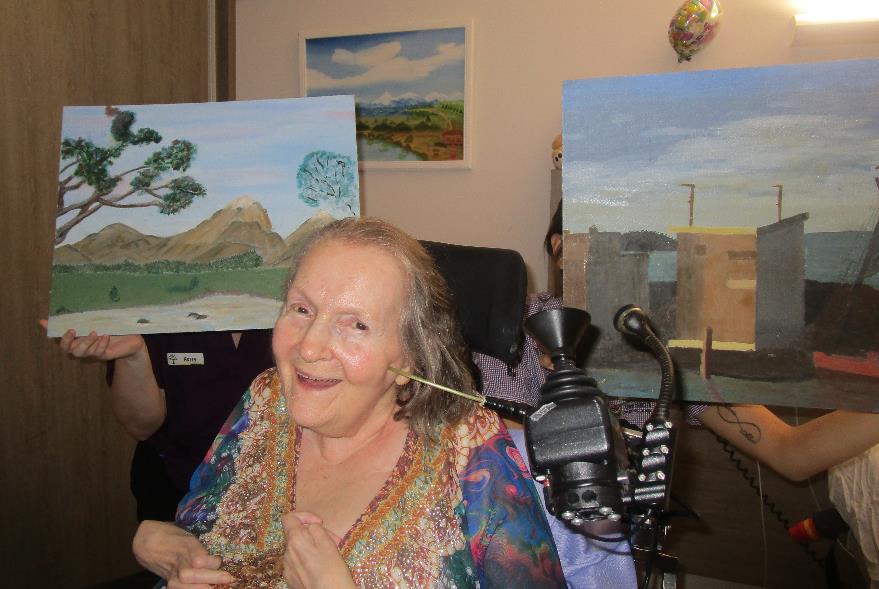 woman in a wheelchair with her paintings