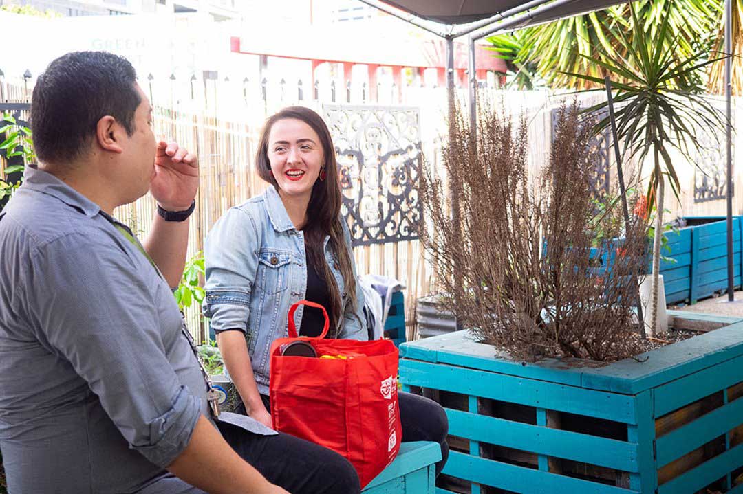 Two people with red shopping bag full of groceries